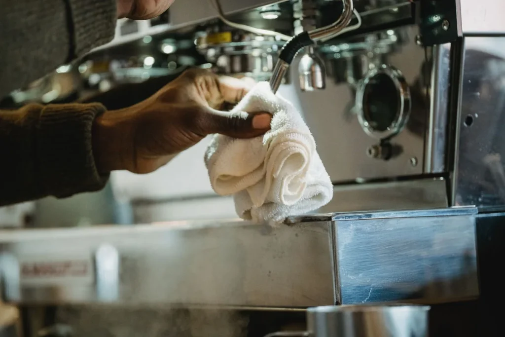 Nettoyage en gros plan d’une machine à boissons avec un chiffon